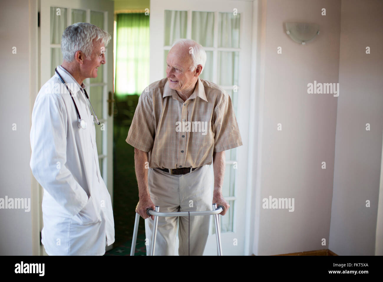 Doctor talking to patient using walker Stock Photo