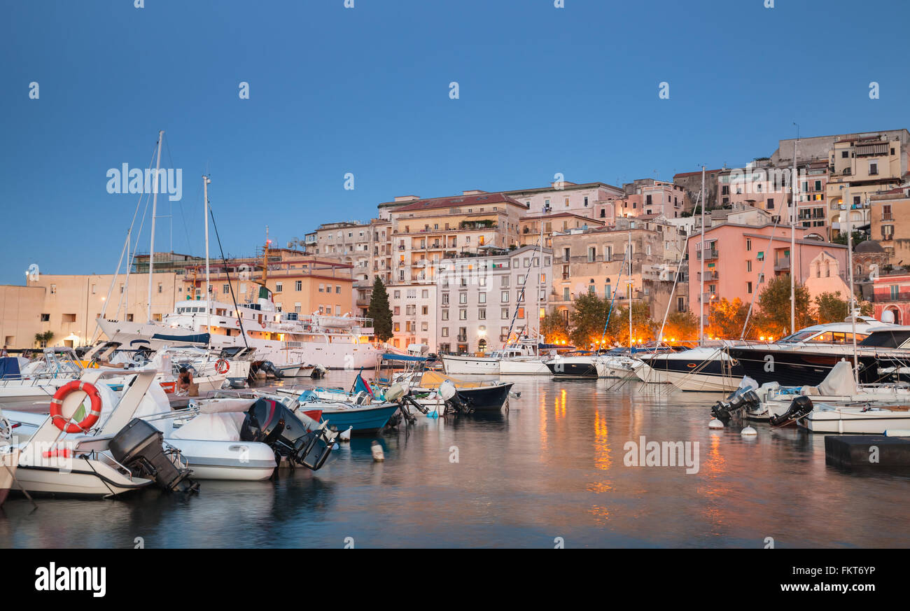 Port with moored motorboats and pleasure yachts. Night cityscape of Gaeta town, Italy Stock Photo