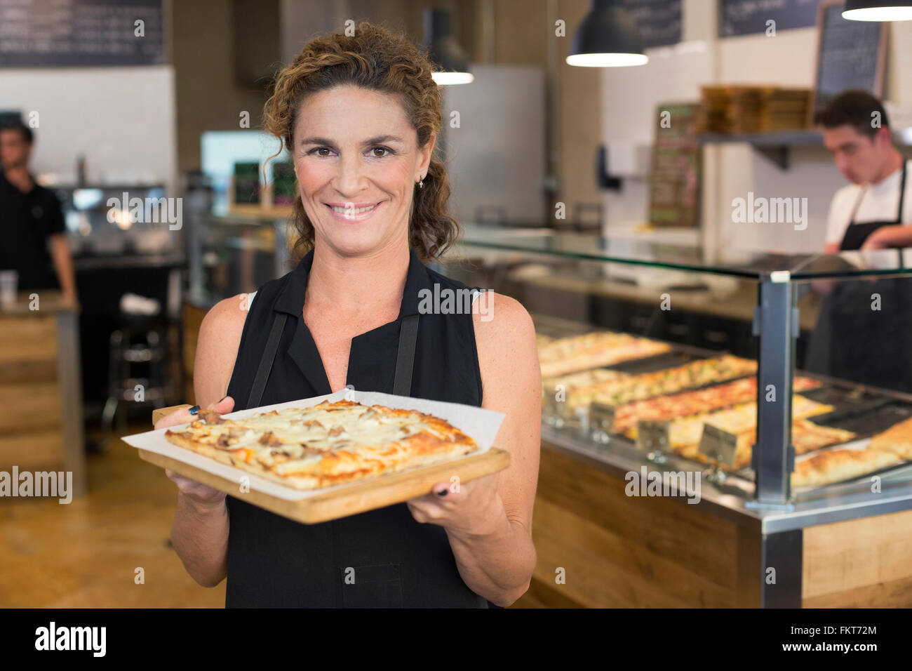 Server holding pizza in cafe Stock Photo