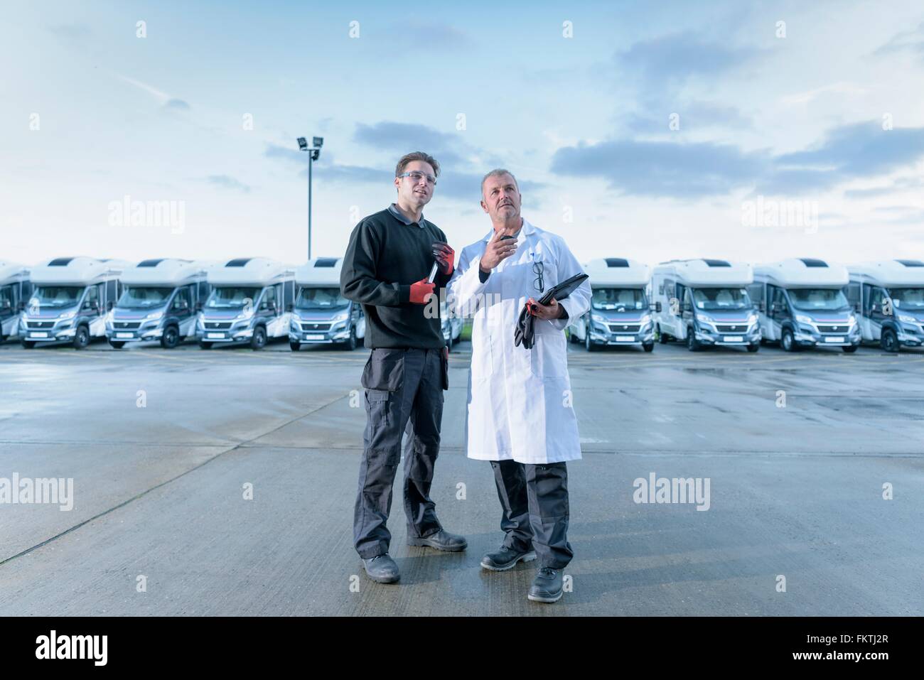 Workers inspecting vehicles on motorhome production line Stock Photo