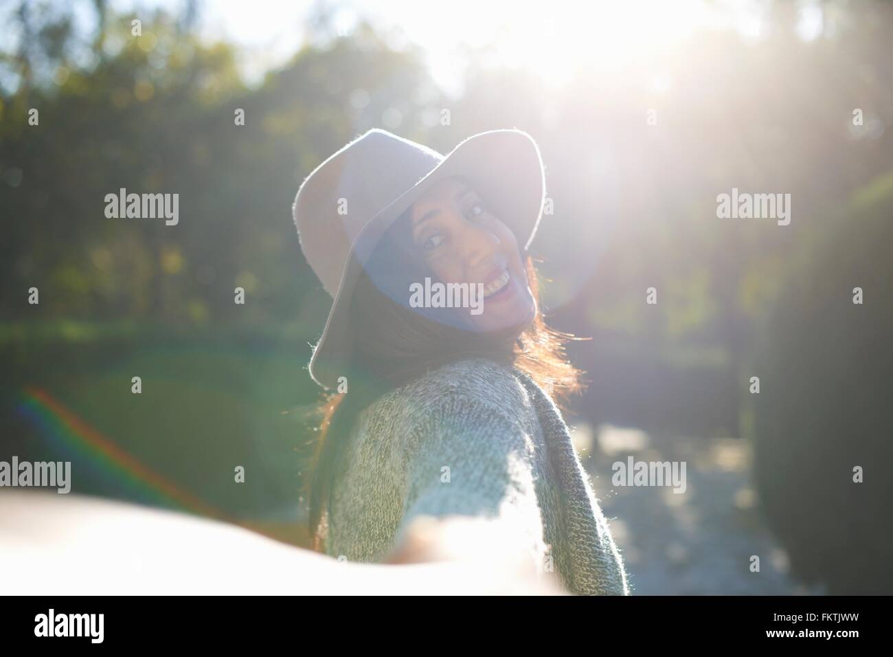 Woman looking over shoulder in park Stock Photo