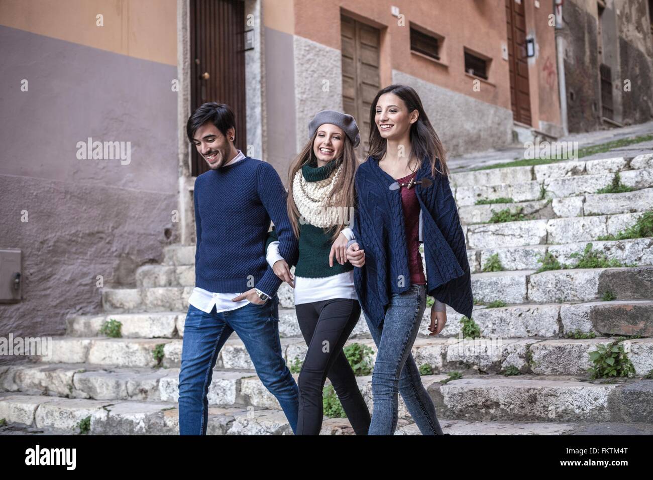 Friends Walking Down Stone Steps Arm In Arm Smiling Stock Photo Alamy