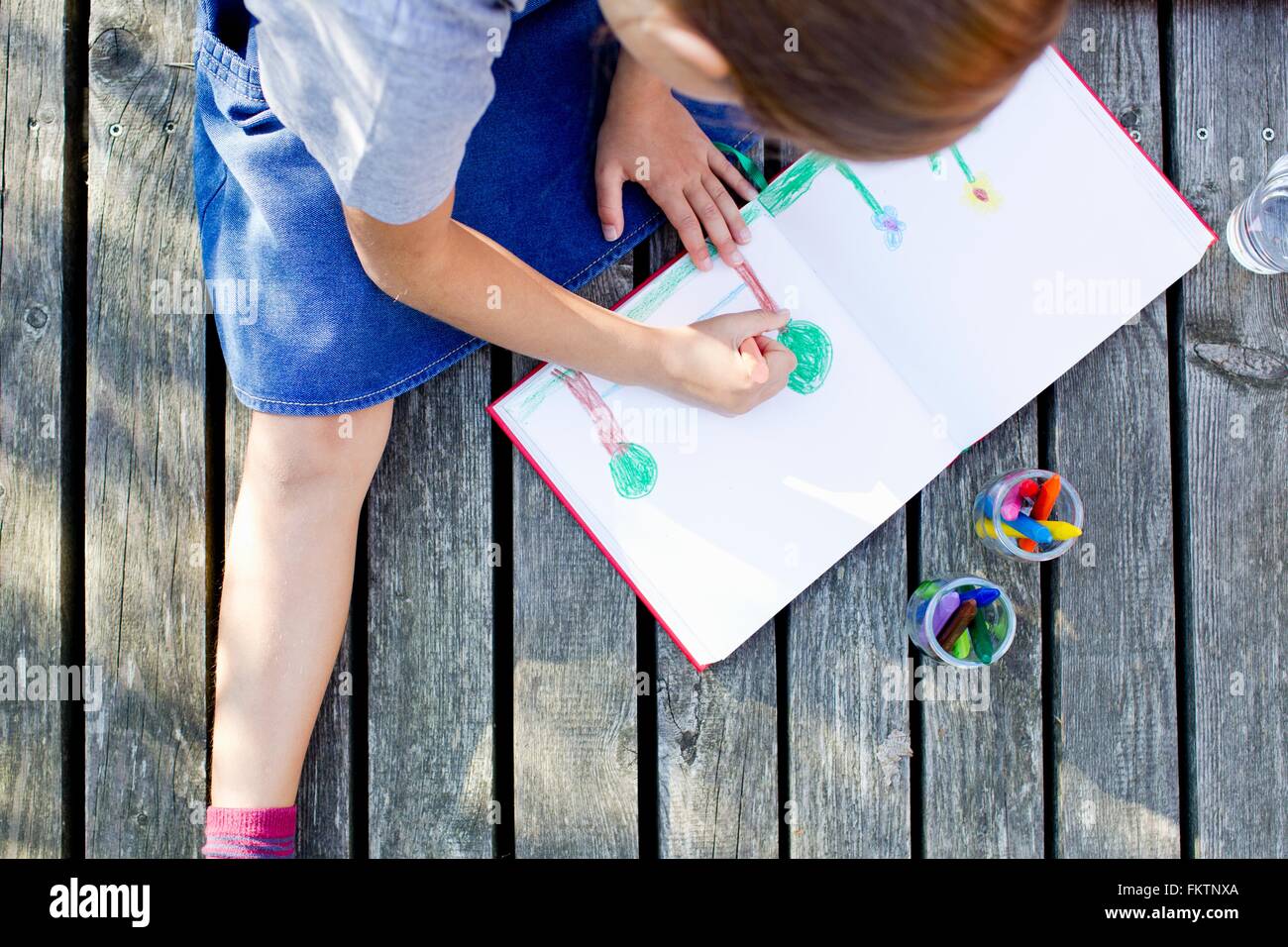 Girl drawing picture in notebook, high angle Stock Photo