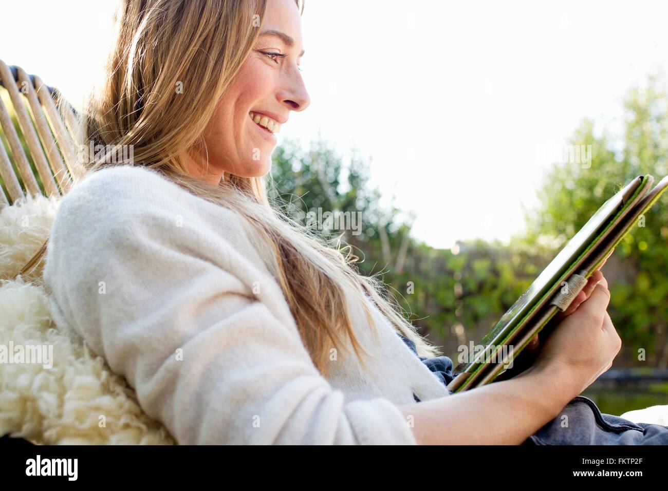 Portrait   mid adult woman using digital tablet, smiling Stock Photo