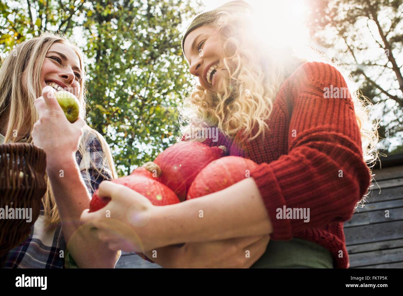Two women holding homegrown produce, low angle Stock Photo