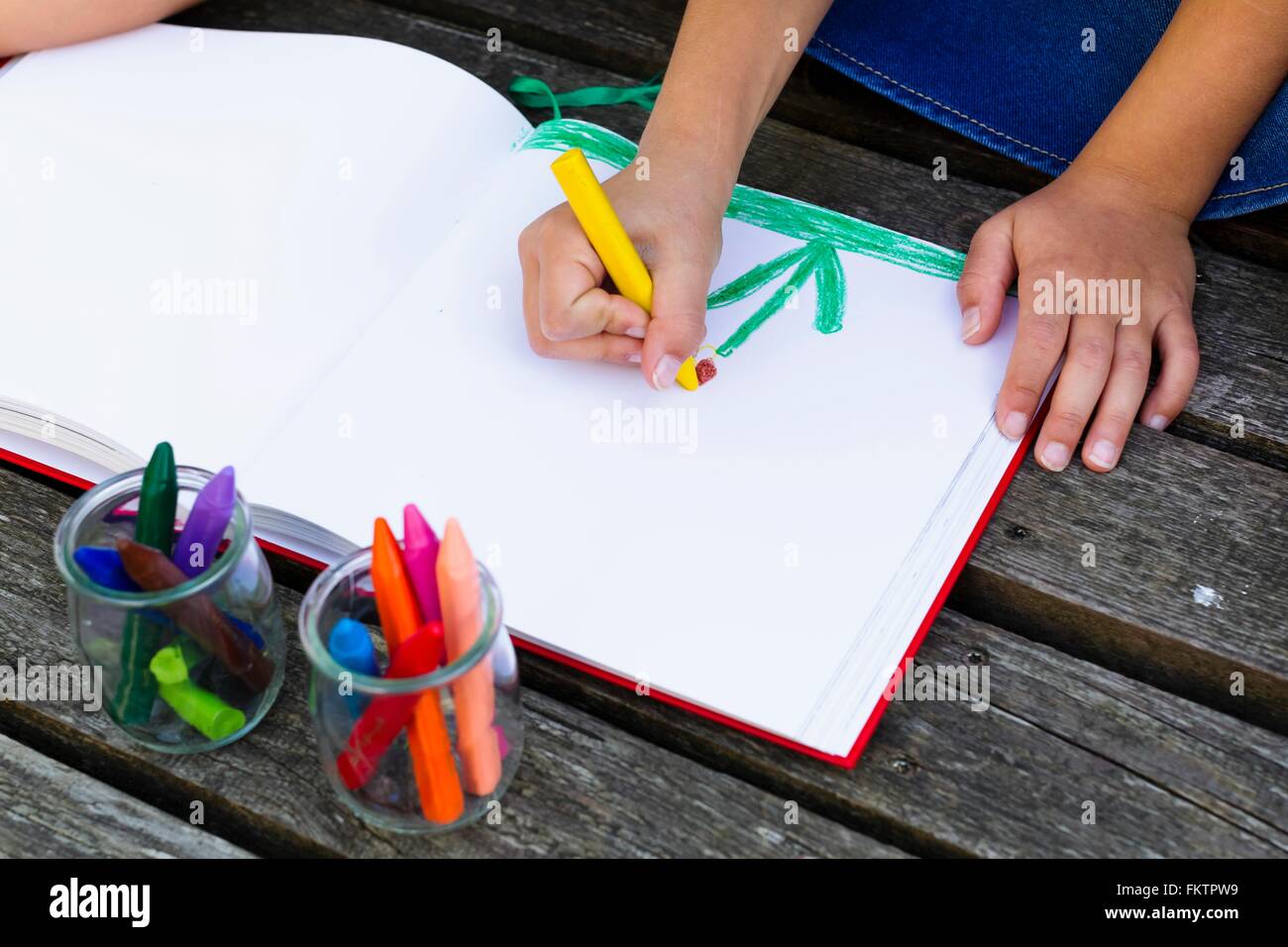 Girl drawing picture in notebook Stock Photo