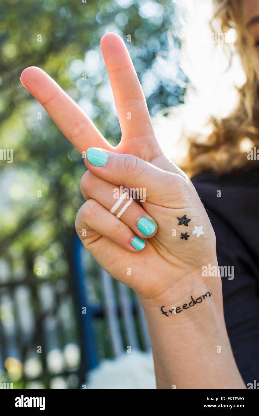 Woman making peace sign with hand Stock Photo