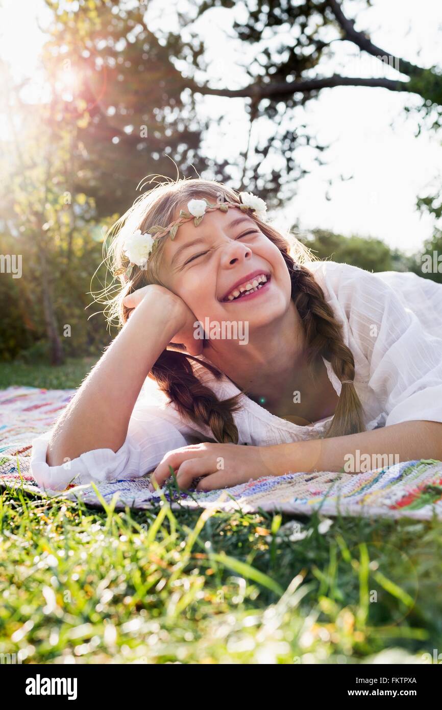 Girl with flowers round head laughing with eyes closed Stock Photo