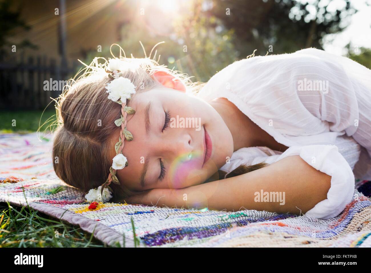 Girl with flowers round head sleeping Stock Photo