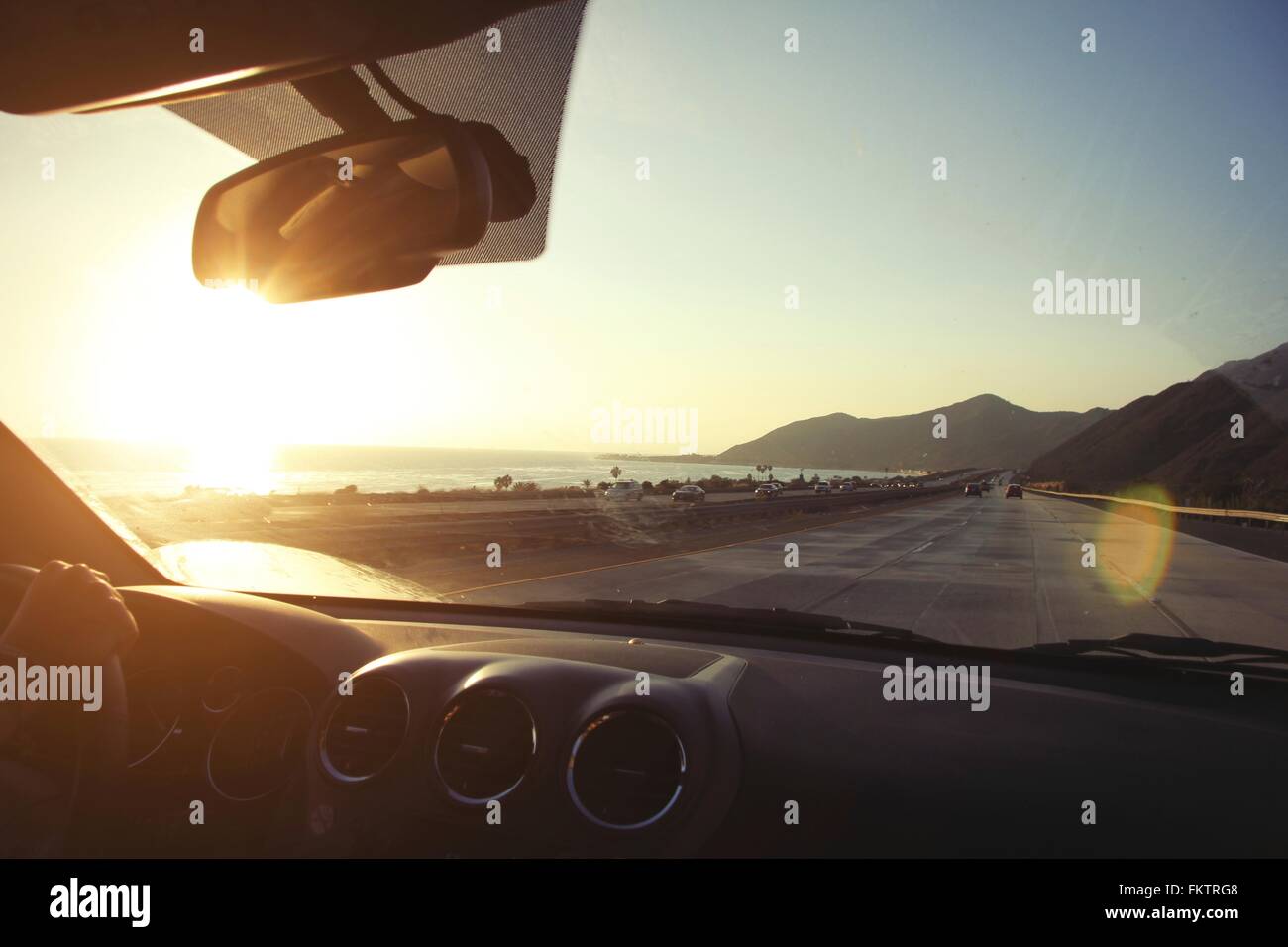 Young woman on the road driving pacific coast highway at sunset, California, USA Stock Photo