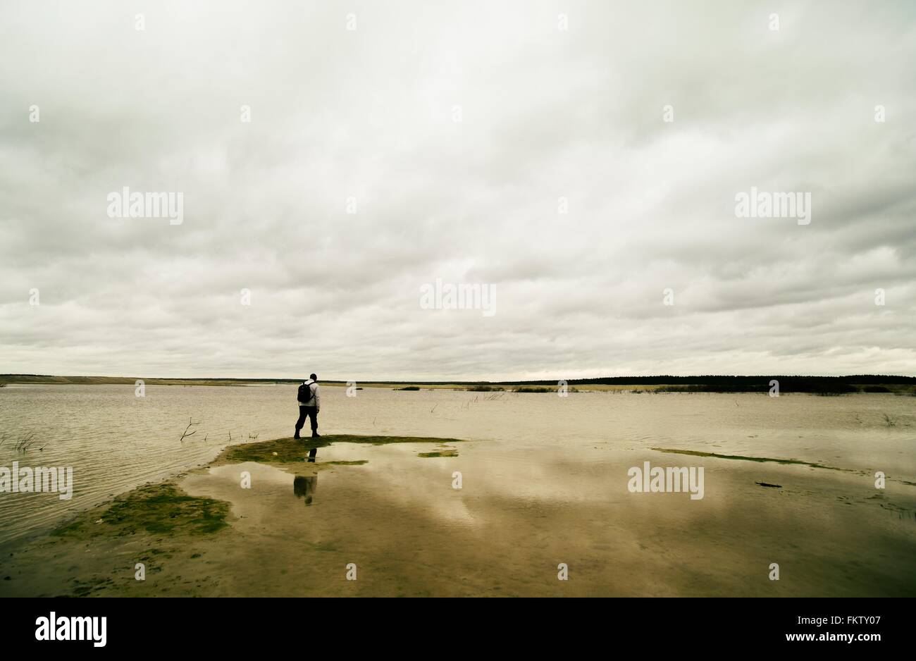 Young man hiking beside lake Stock Photo
