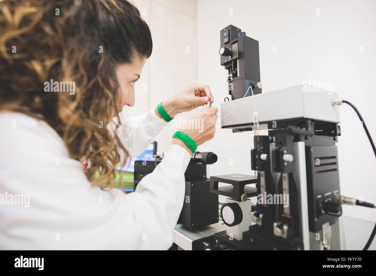 Female scientist looking at contact angle, preparing instrument for drop measurement on a specific substrate Stock Photo