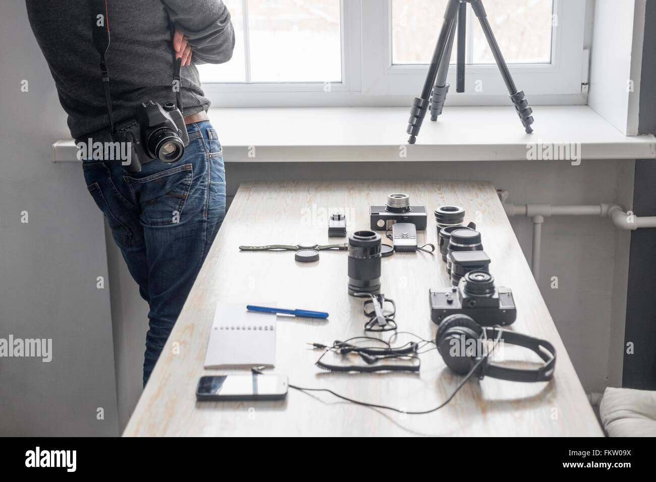 Male photographer next to photography equipment on studio desk Stock Photo