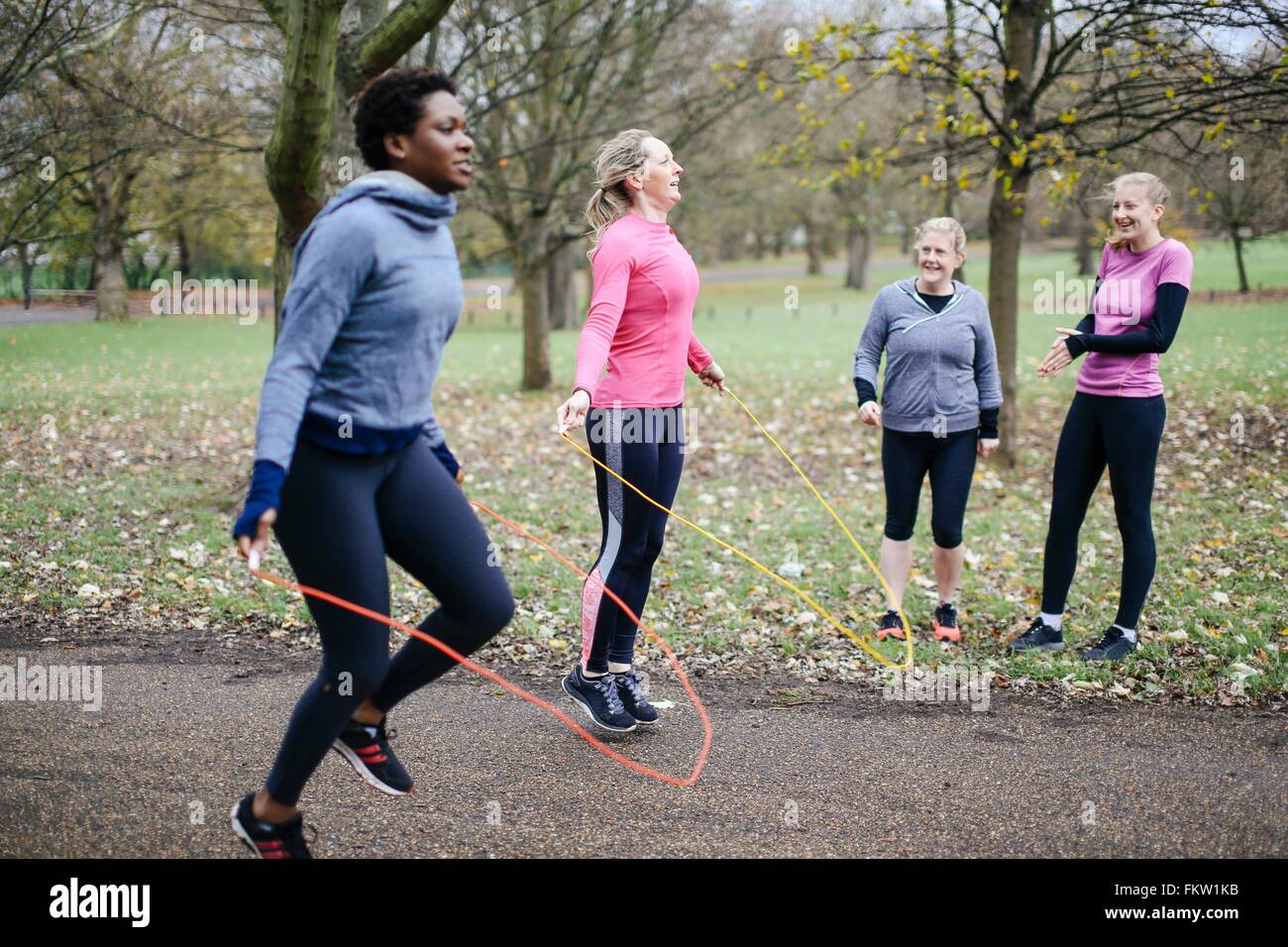 Women and teenager competing with skipping rope in park Stock Photo