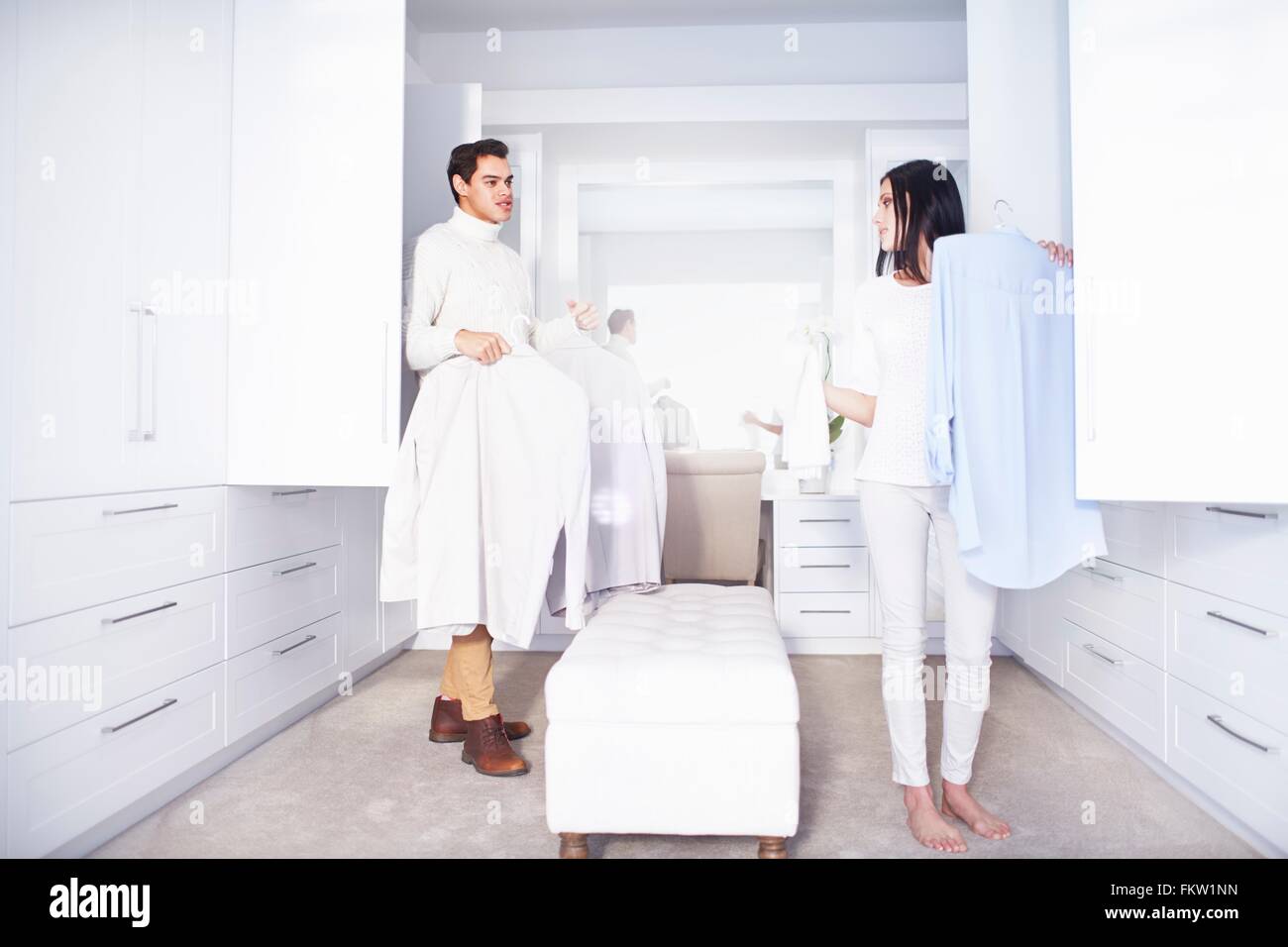 Young couple making decisions whilst getting ready  in bedroom Stock Photo