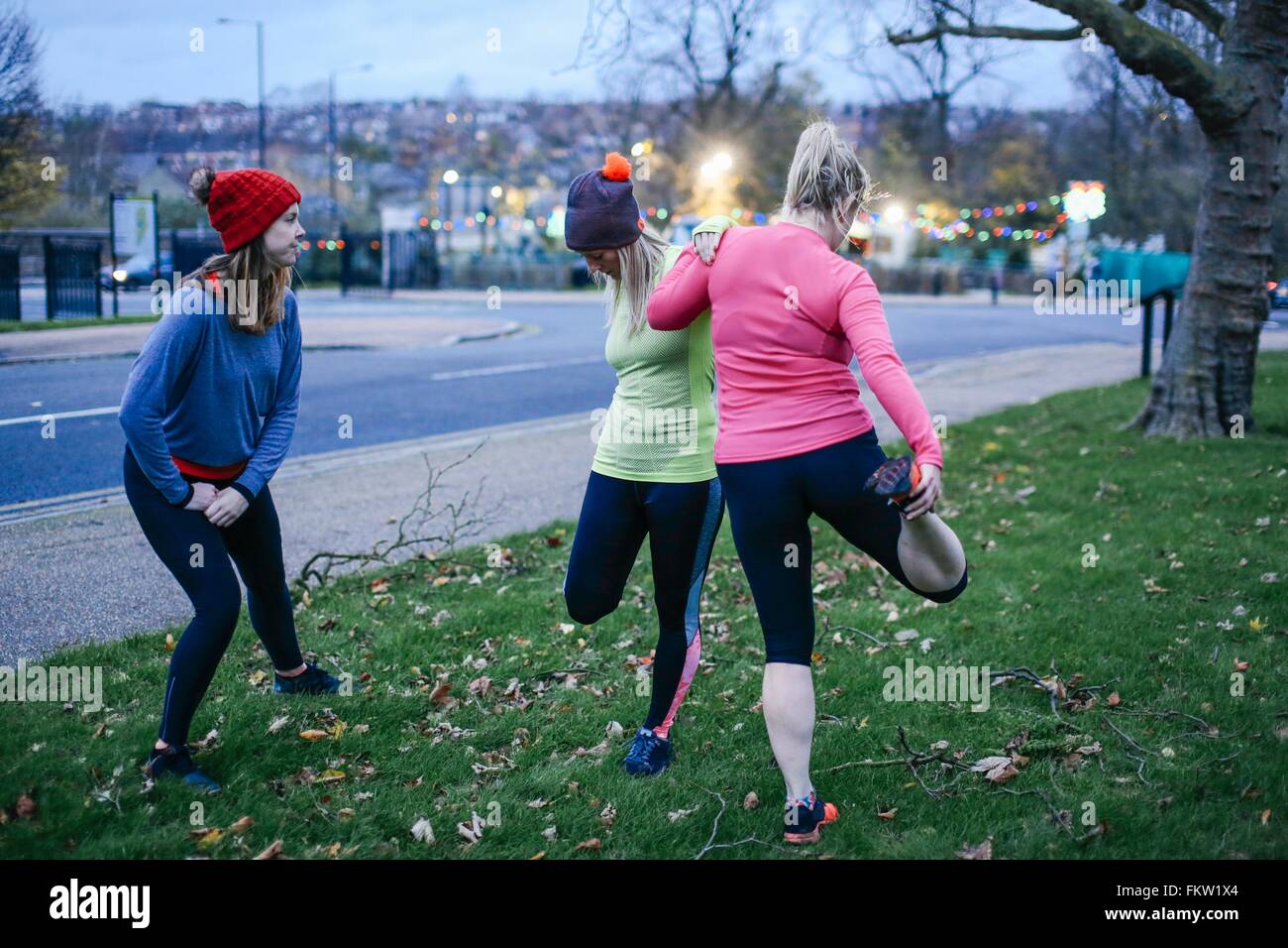 Female runners warming up on city verge at dusk Stock Photo Alamy