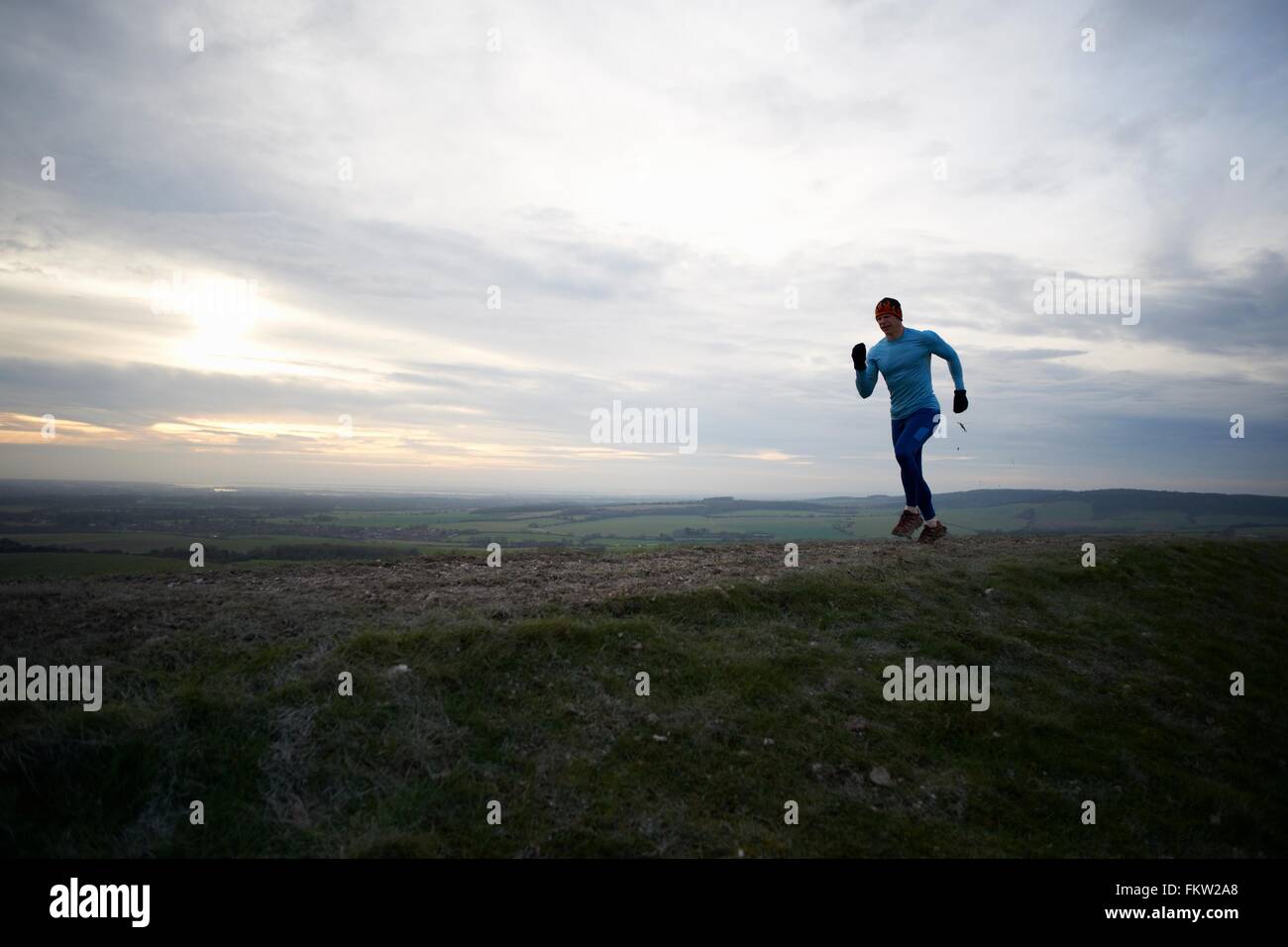 Full length view of fell runner running against dramatic sky Stock Photo