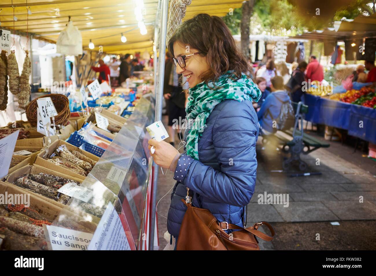 Young woman buying fresh food at market stall Stock Photo