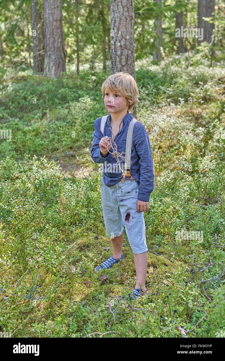 Portrait of young boy wearing retro clothes standing in forest Stock Photo