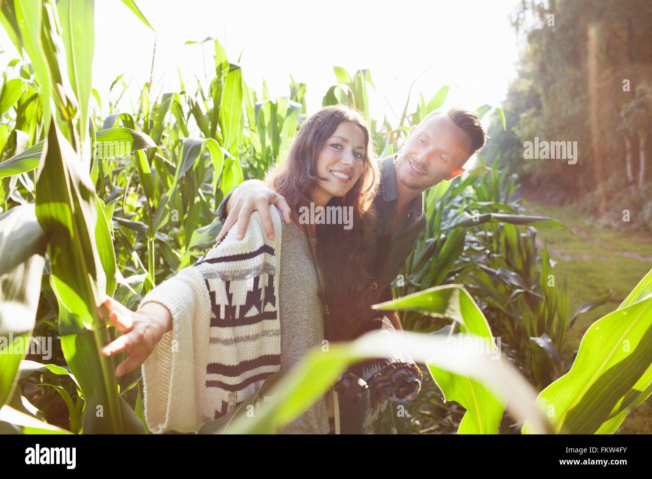 Couple amongst corn plants in field Stock Photo - Alamy