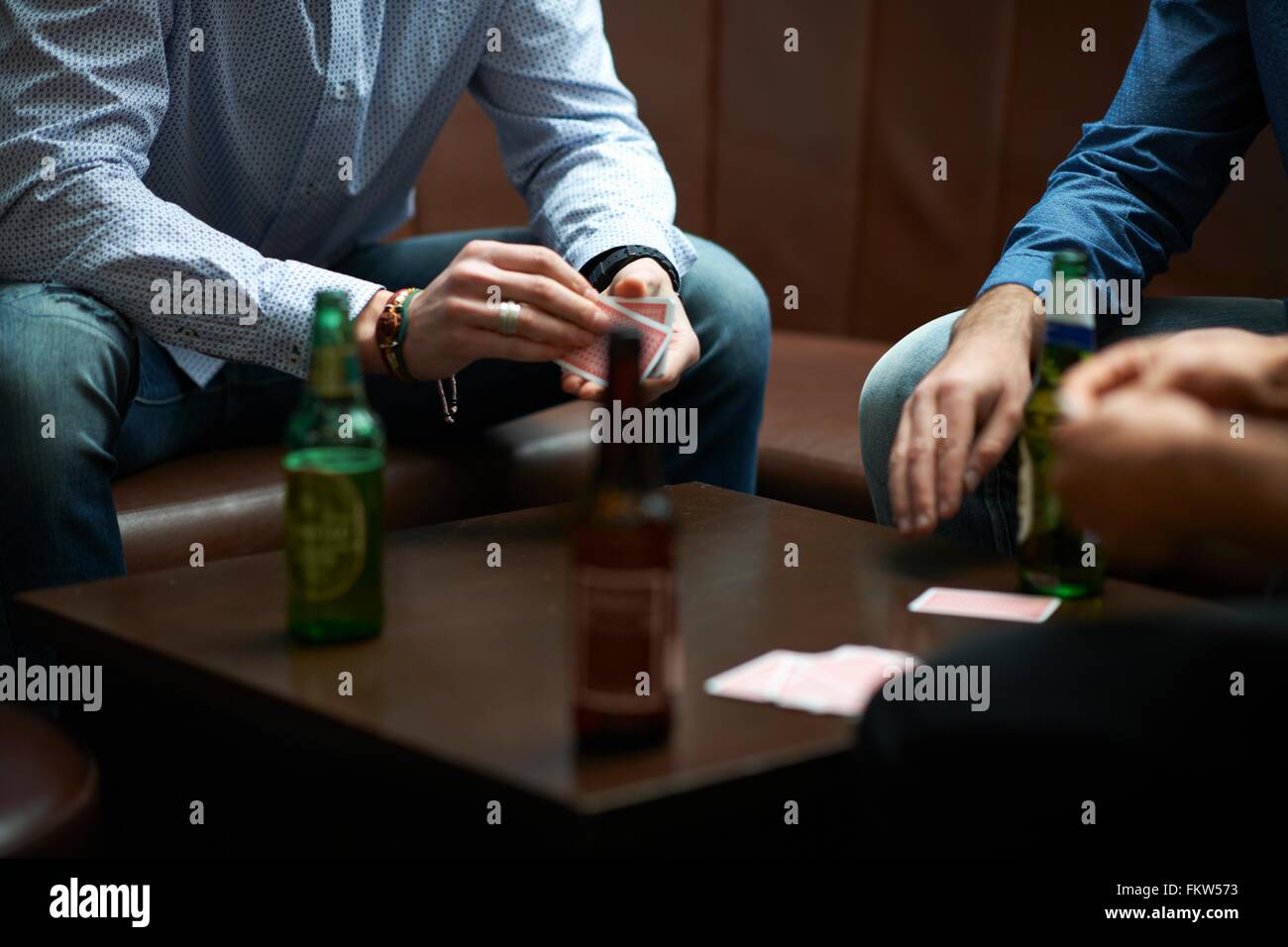 Hands of three men playing cards in traditional UK pub Stock Photo