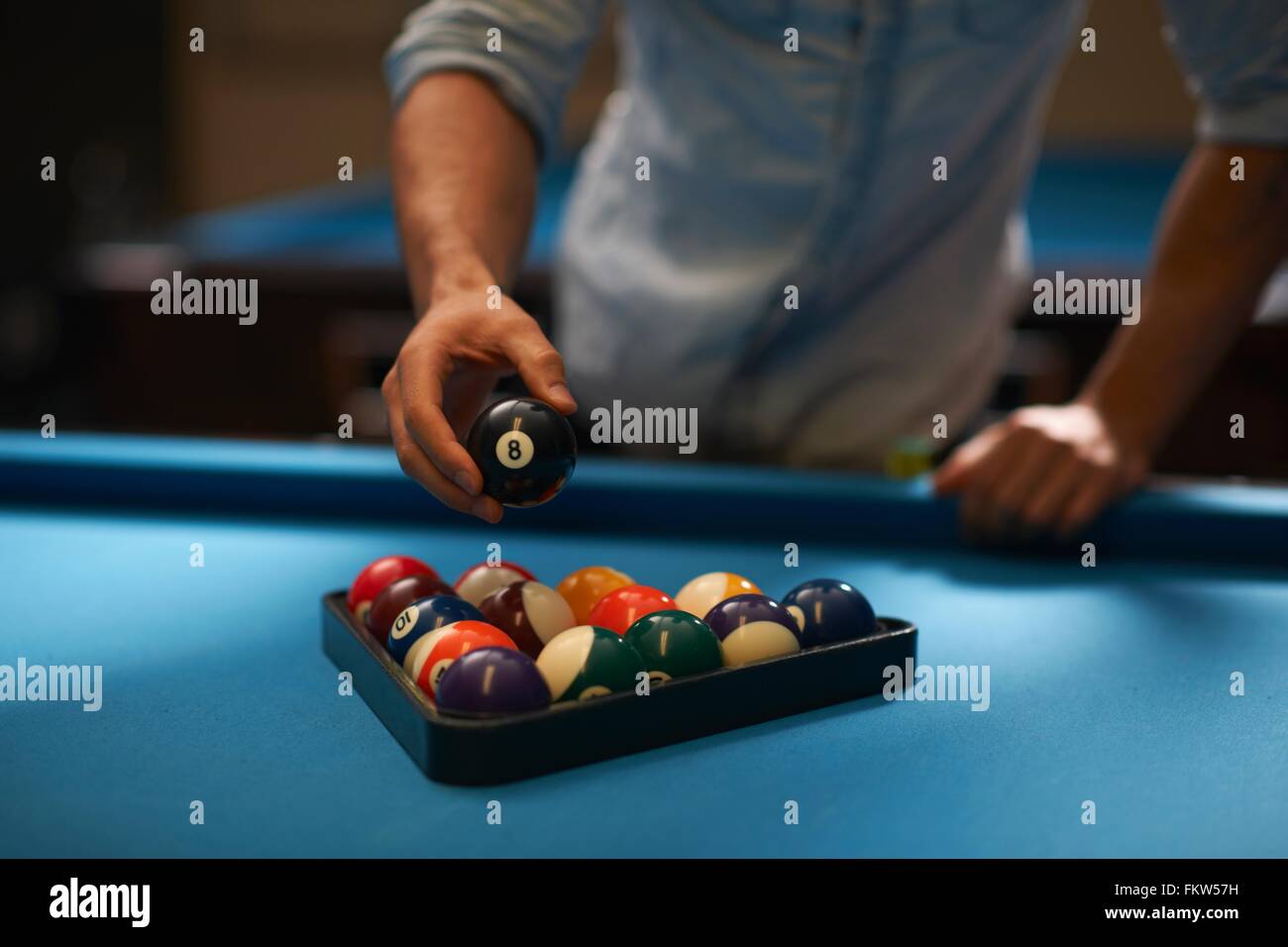 Man arranging balls into triangle on pool table Stock Photo Alamy