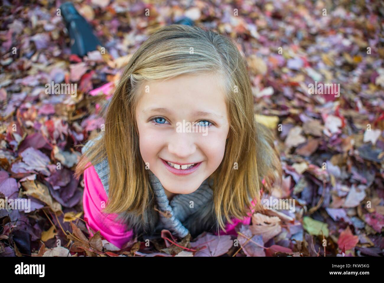 Girl lying on autumn leaves in garden Stock Photo - Alamy