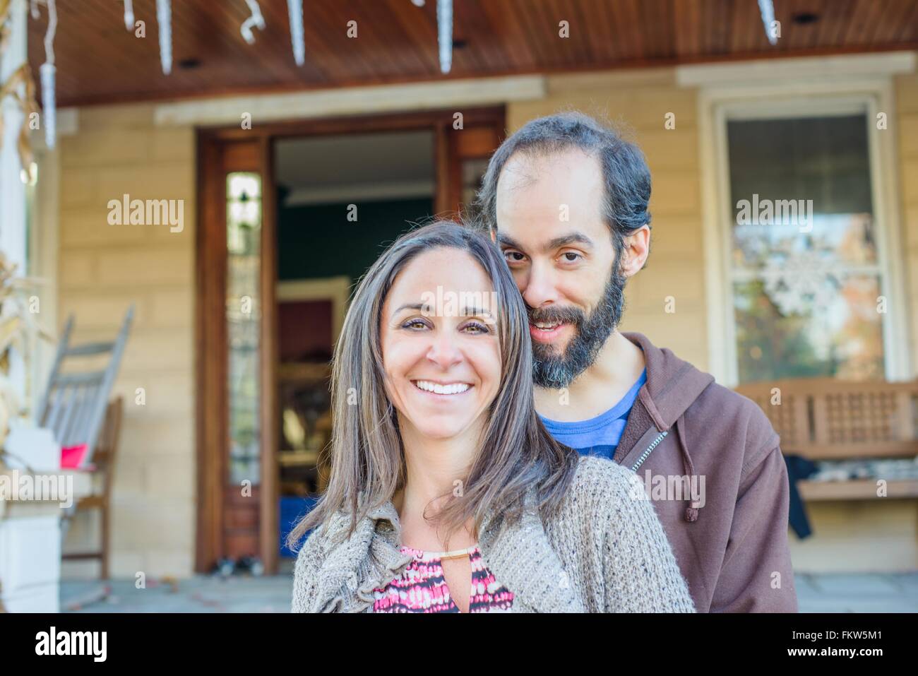 Couple smiling in front of house Stock Photo