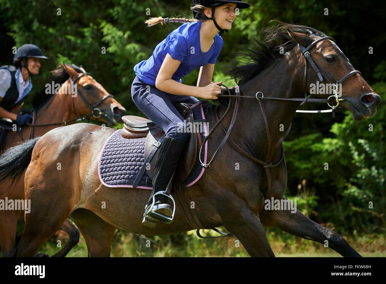 Side view of girl riding horse smiling Stock Photo