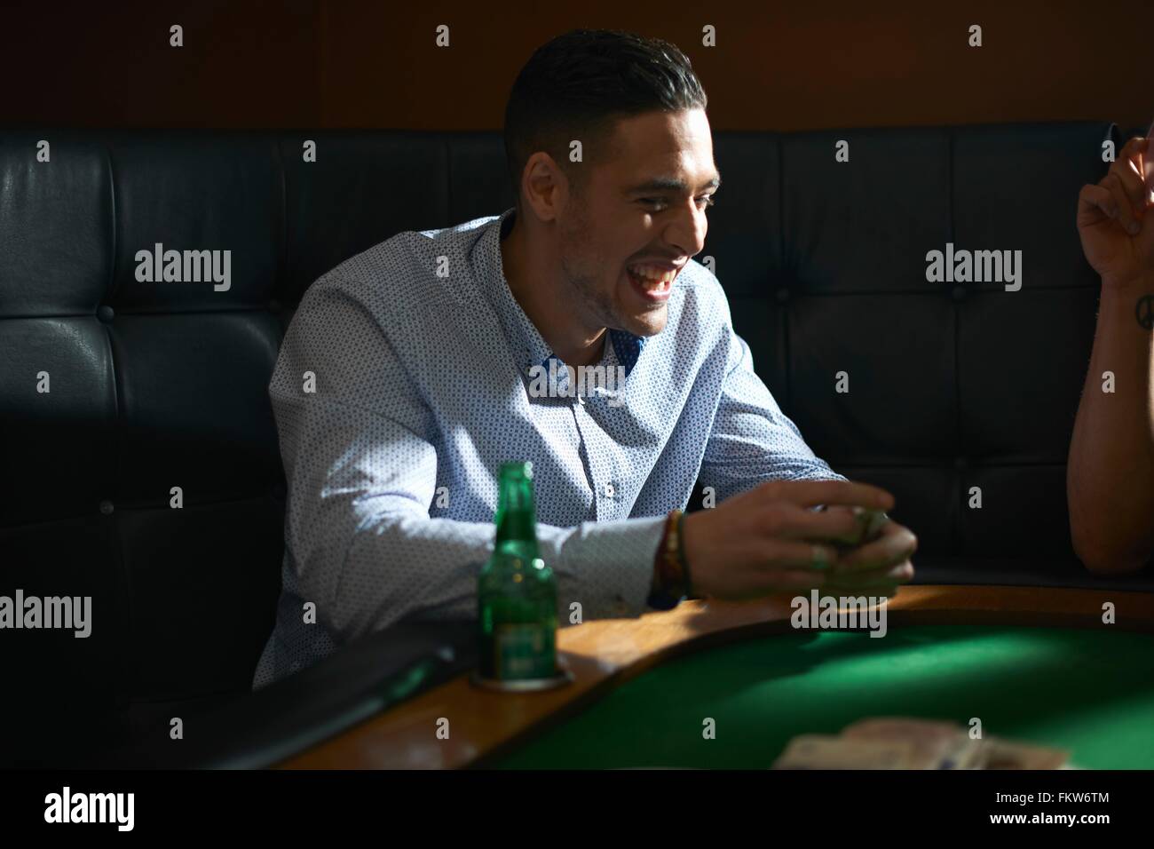 Man shuffling playing cards at pub card table Stock Photo