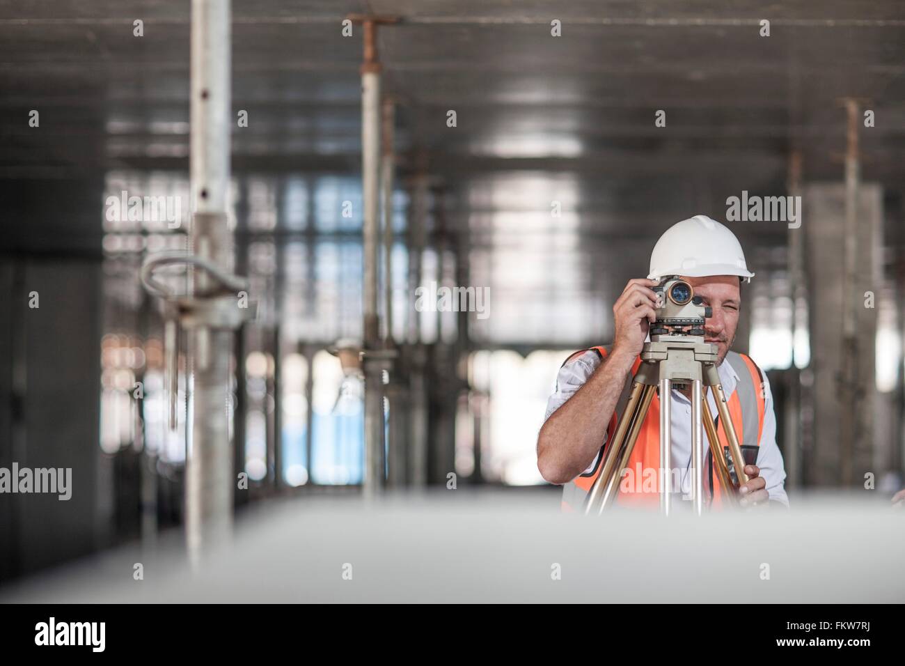 Mid adult male surveyor using theodolite on construction site Stock Photo