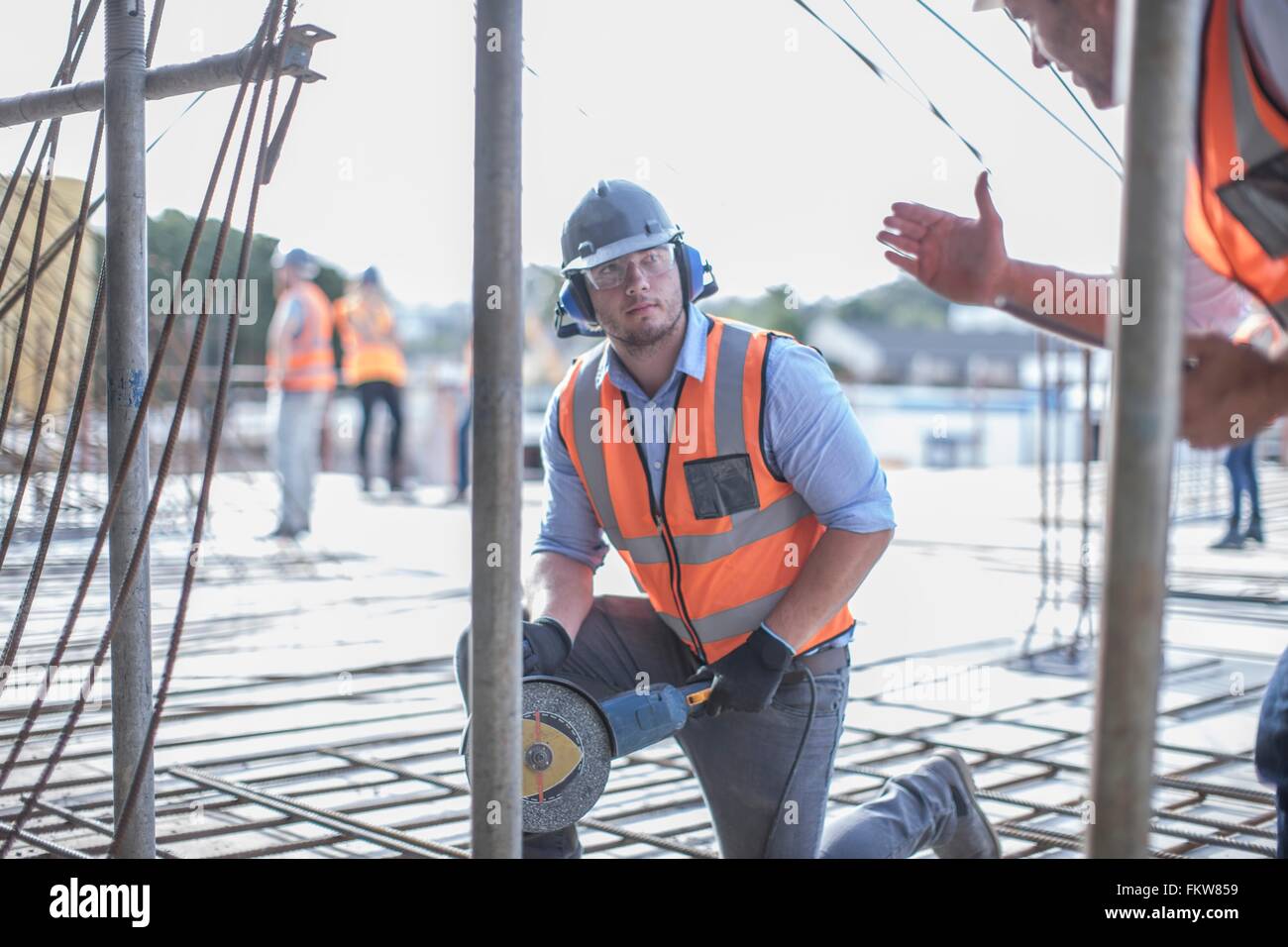 Site manager explaining to builder on  construction site Stock Photo