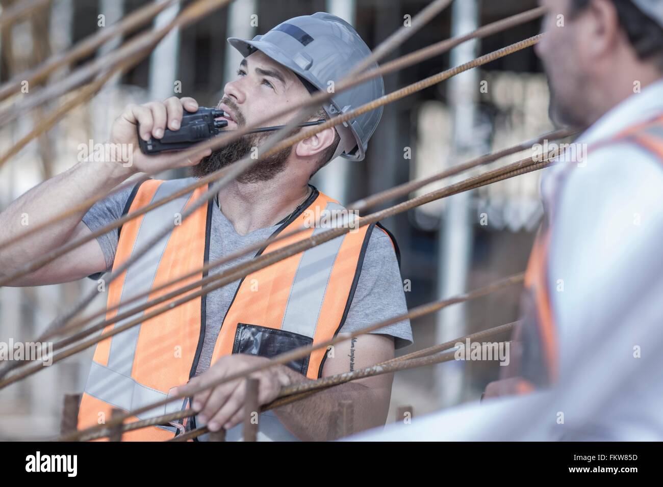 Site manager using walkie talkie on  construction site Stock Photo