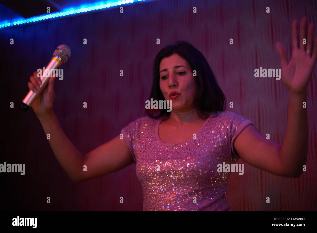 Woman singing karaoke Stock Photo