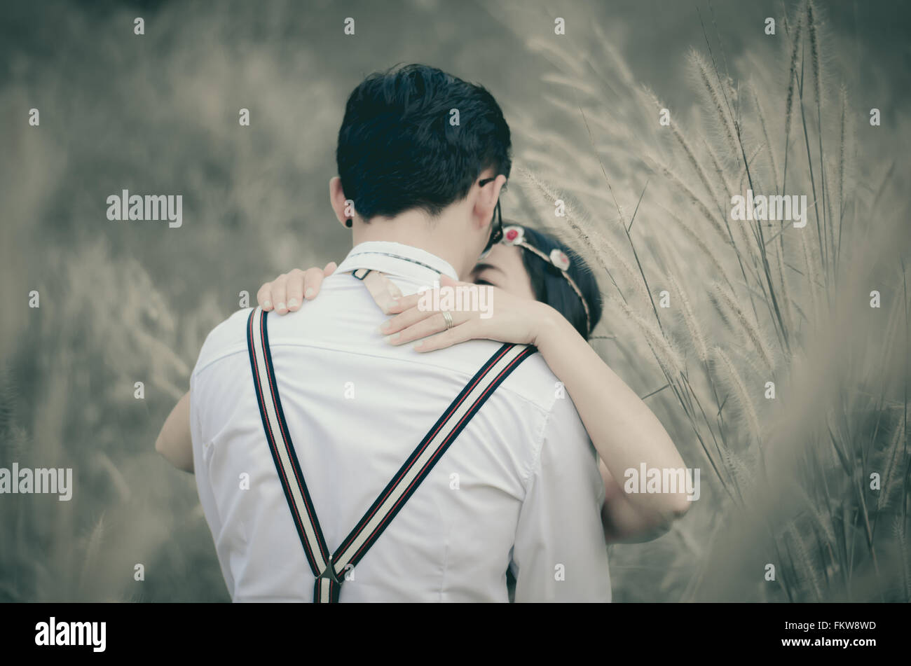couple kiss and embracing in grass field Stock Photo