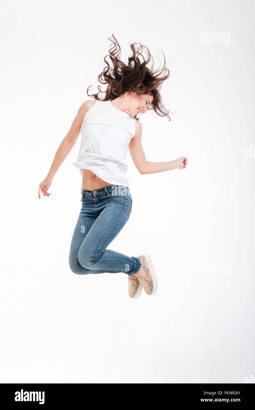Full length portrait of a happy woman jumping isolated on a white ...