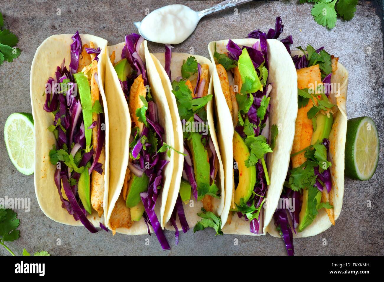 Spicy fish tacos with red cabbage lime slaw and avocado, overhead view