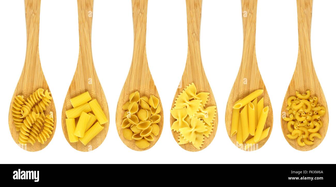 Wooden cooking spoons filled with various types dry pasta isolated on a