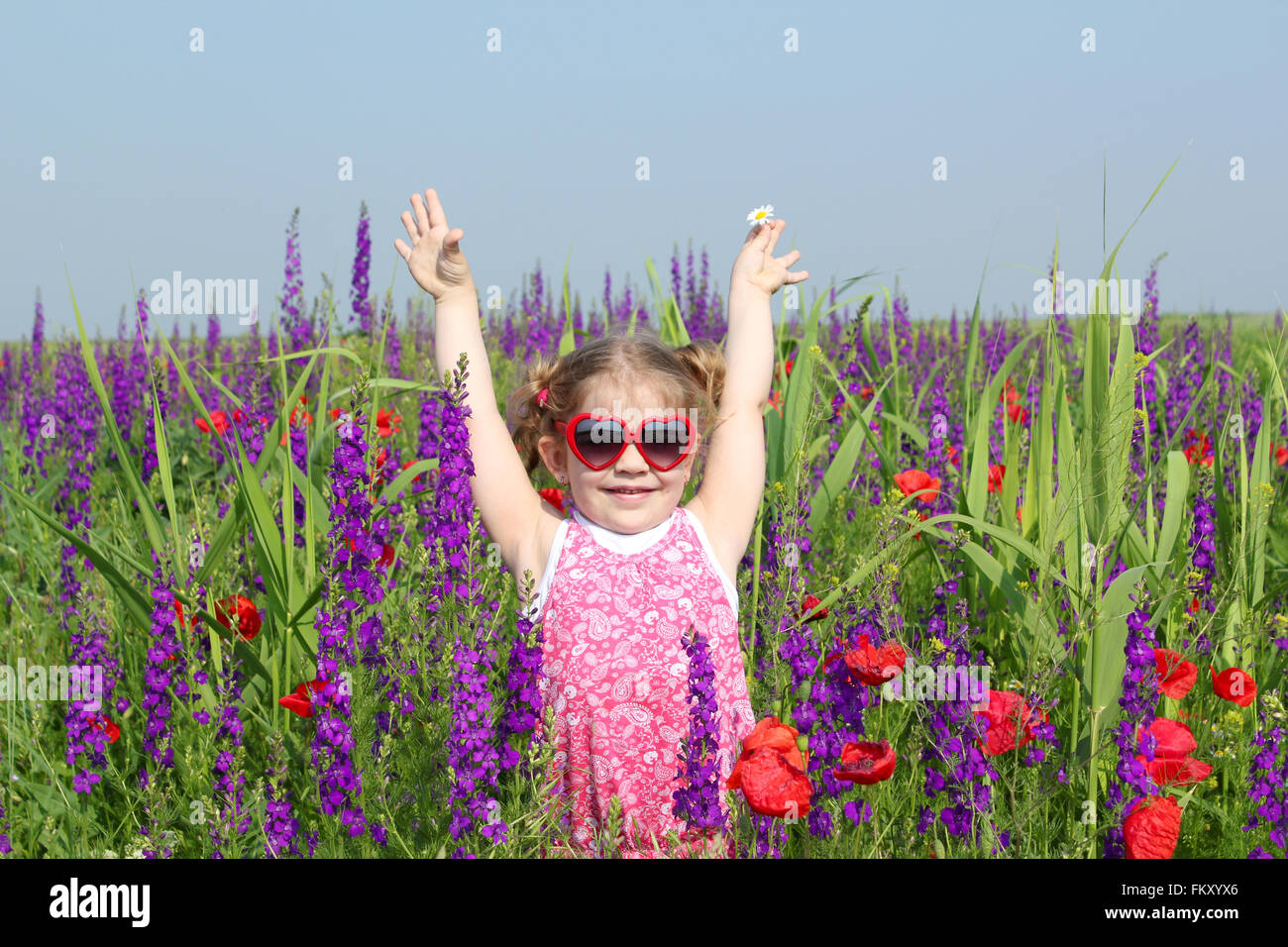 happy little girl standing in colorful meadow Stock Photo - Alamy