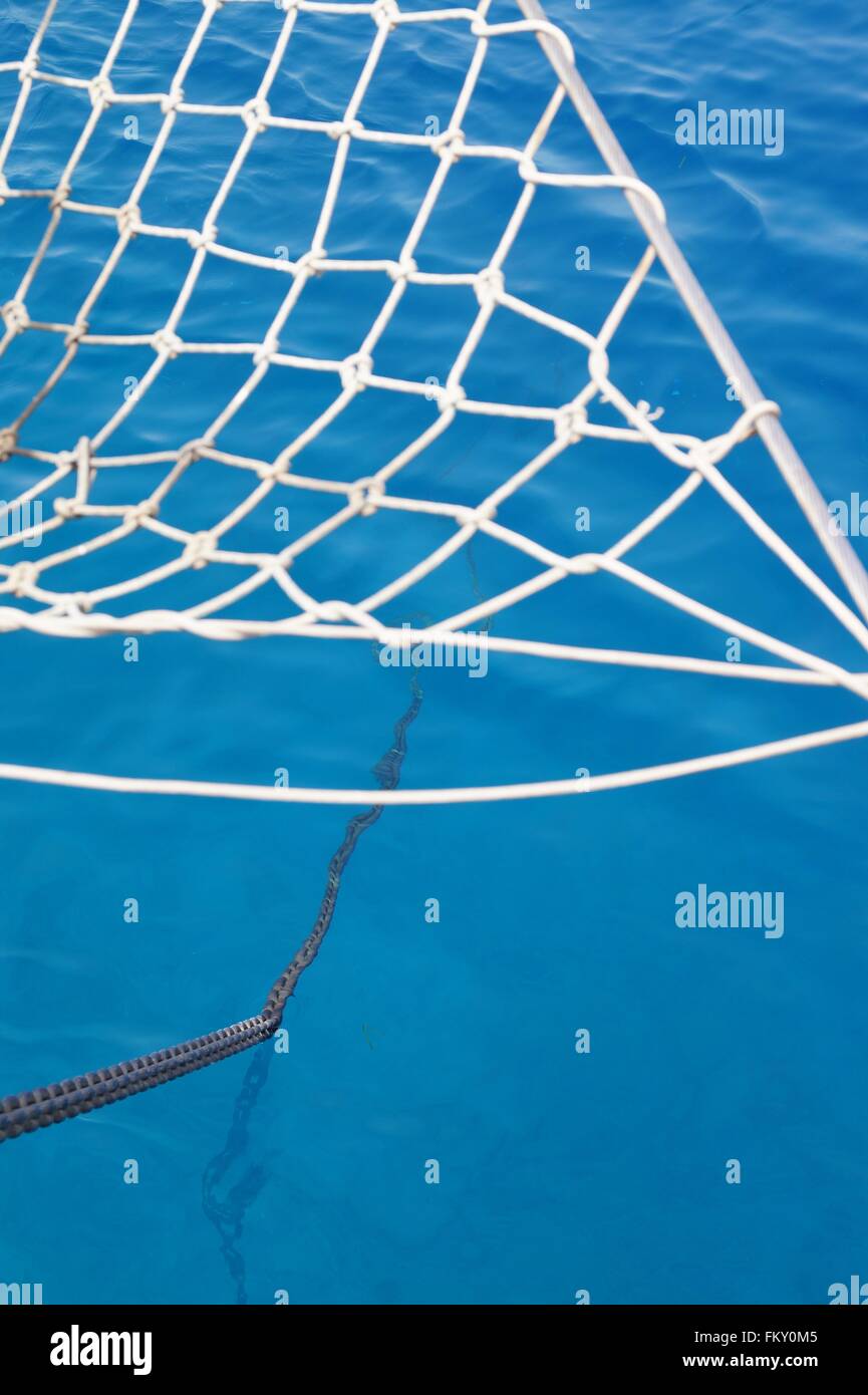 Anchor chain into clear ocean water with focus on chain going into the ...