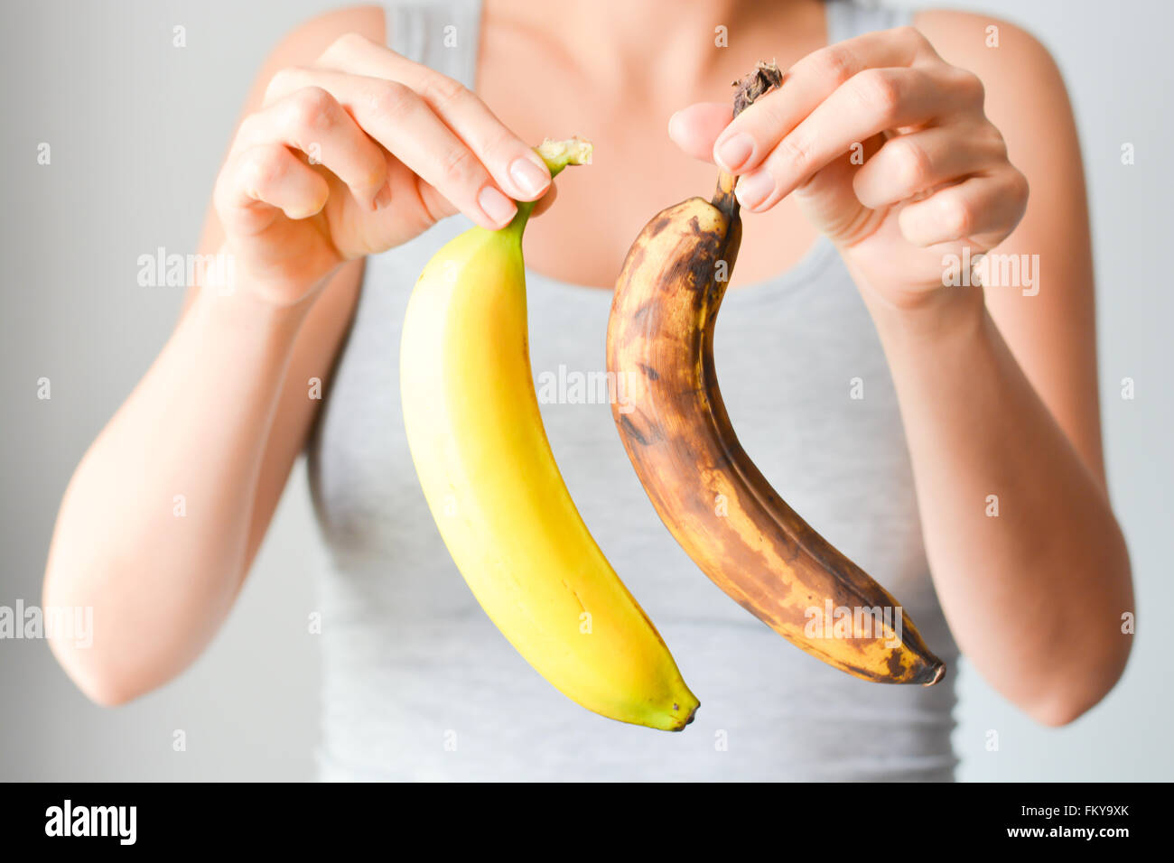 Fresh and overripe bananas on woman hand Stock Photo