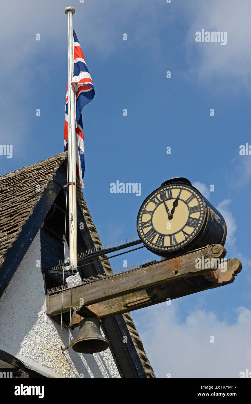Old clock and British Union Jack flag on building in Burford ...