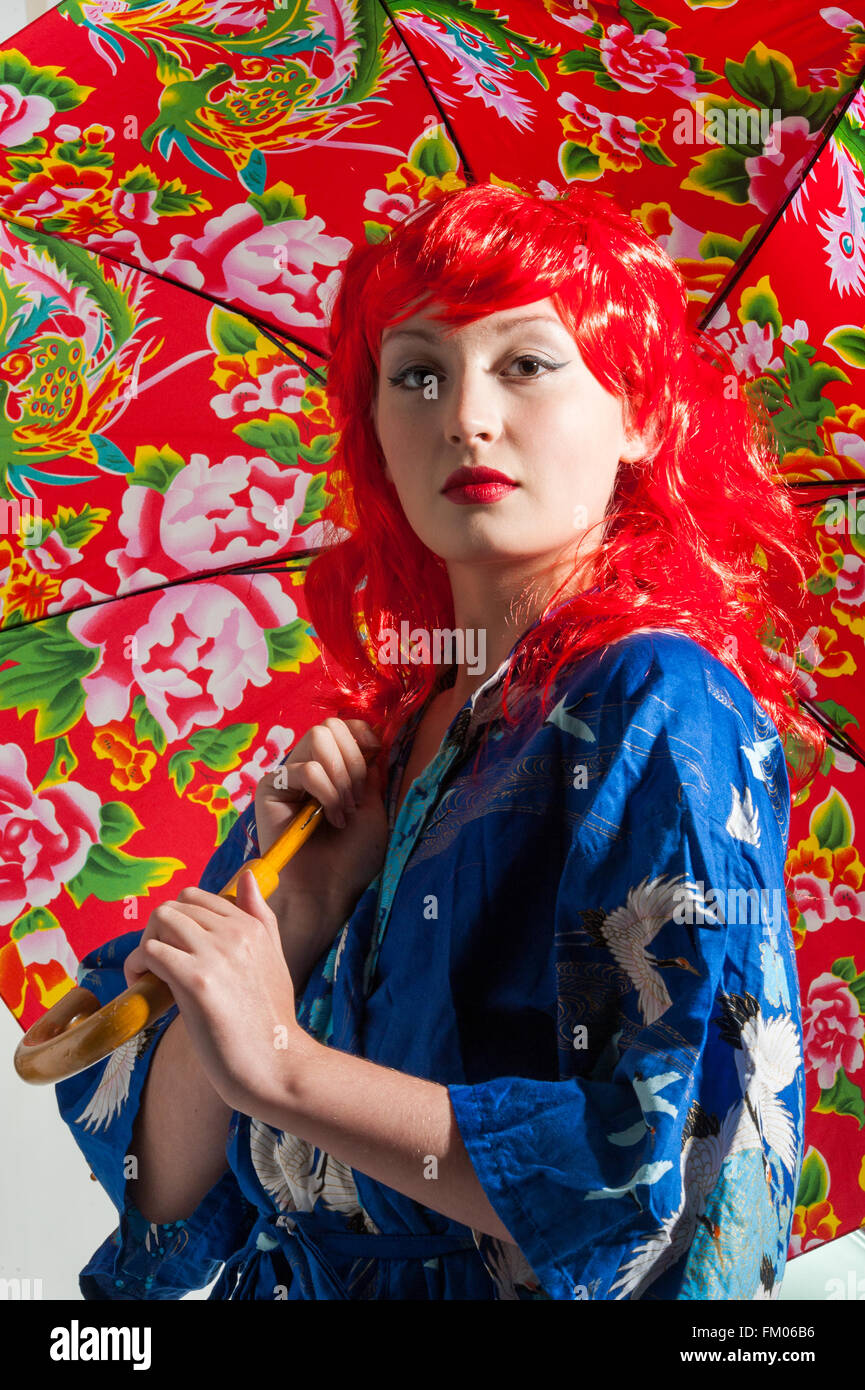 young lady with red hair and colorful umbrella Stock Photo