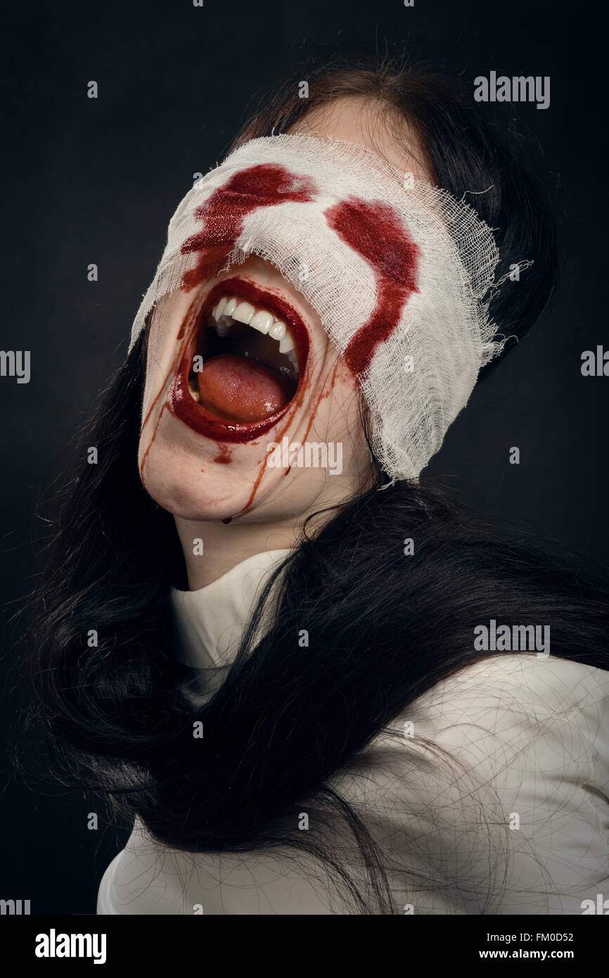 screaming crazy woman vampire on black background Stock Photo