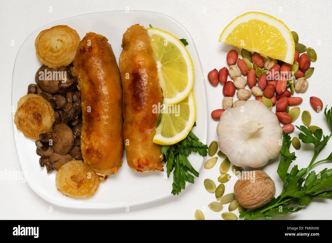 Fried sausage with mushrooms and onions on a white plate. Stock Photo