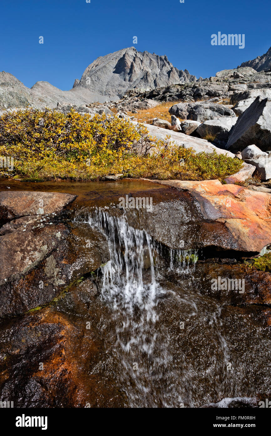 WYOMING - Colorful rock at a small cascade with Fremont Peak beyond in the Indian Basin area of the Wind River Range. Stock Photo