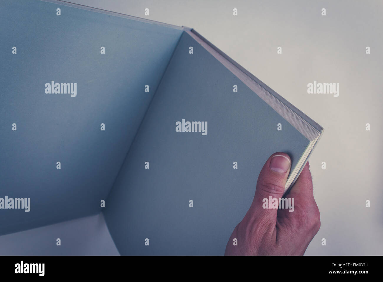 hand holding open book with blank pages Stock Photo