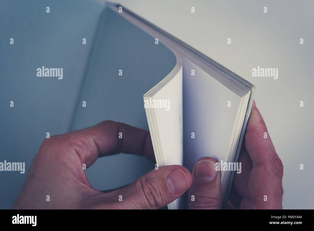 hands turning pages in empty book with blank pages Stock Photo