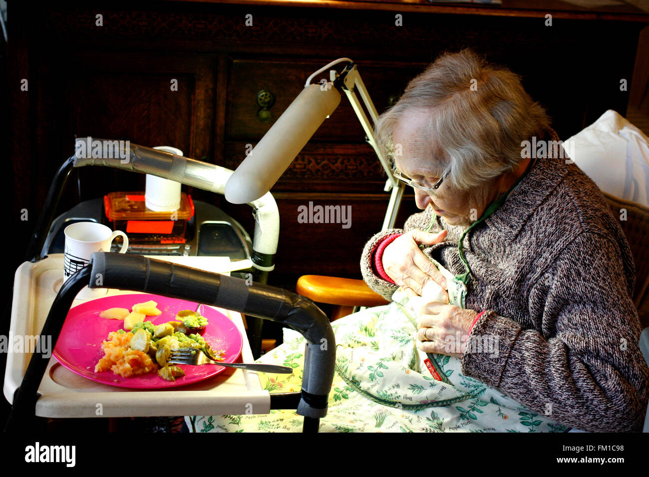 senior citizen lady at home seated having her supper london uk march 2016 Stock Photo