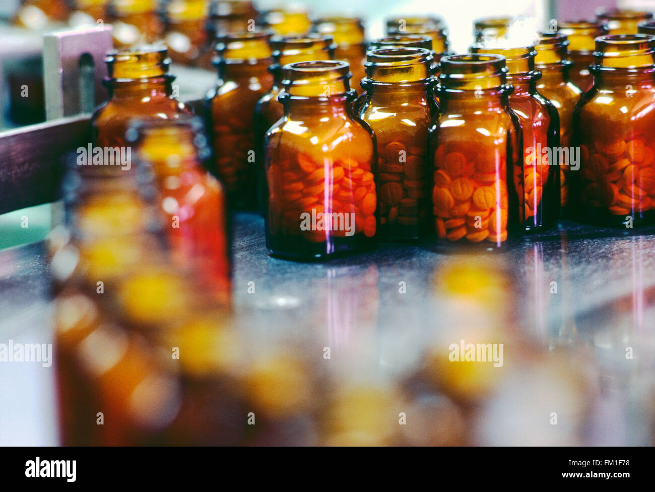 Bottled pills in manufacturing and packaging production line of pharmaceutical company Stock Photo